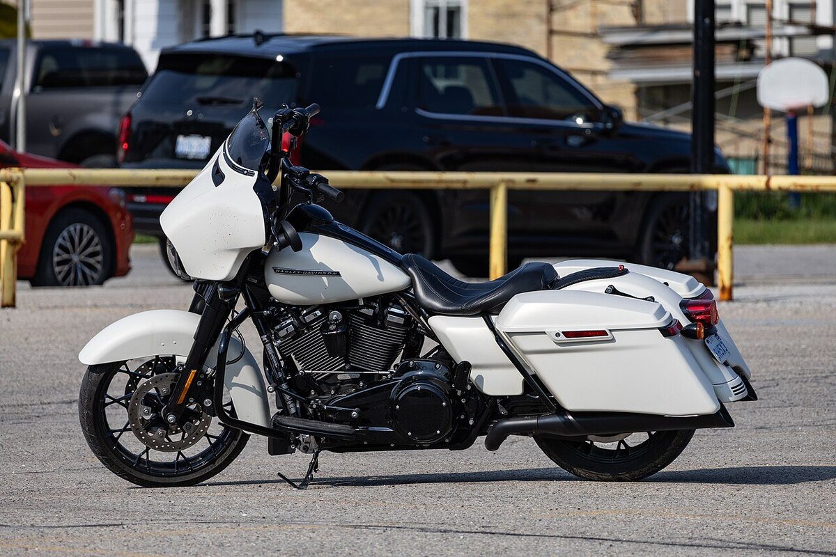 Harley-Davidson Street Glide blanche garée sur un parking, vue de profil