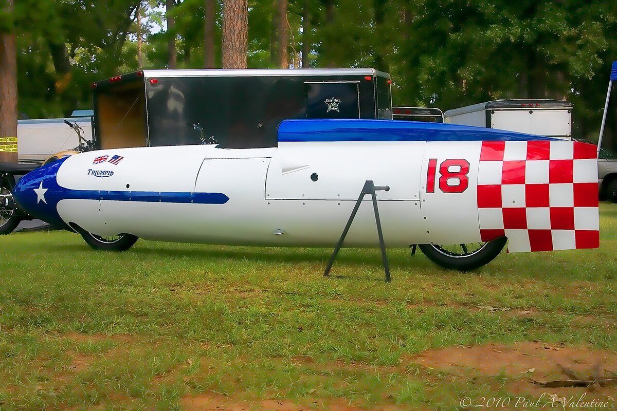 Caréné de record de vitesse Triumph Texas Ceegar, blanc, bleu et rouge, posé sur l'herbe