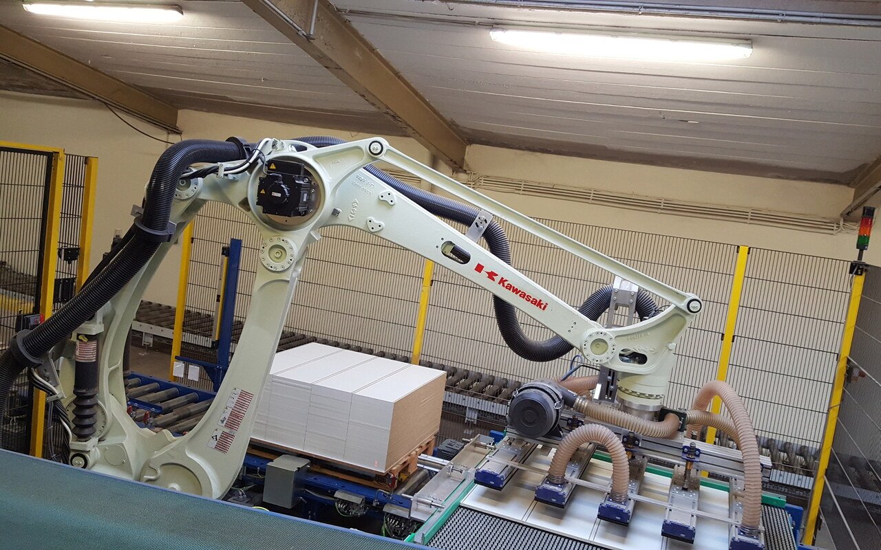 Bras robotisé Kawasaki blanc de palettisation en service dans une usine